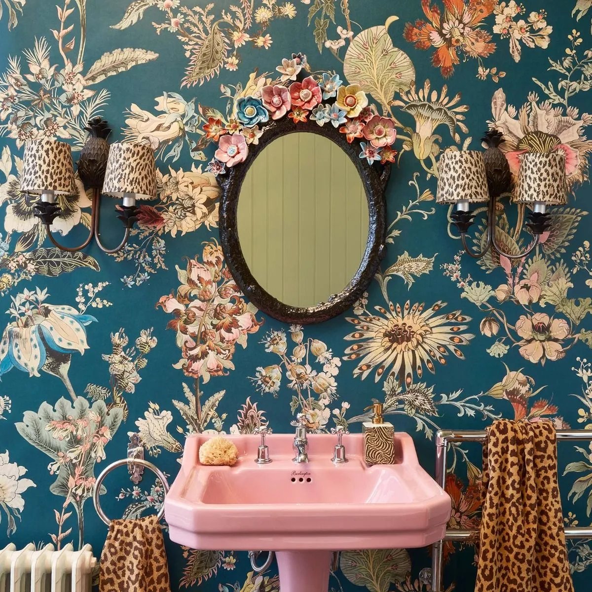 Badezimmer mit Blumentapete hinter dem Waschbecken